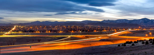 A panoramic dusk view of U.S. Highway 285 winding at the foothill of Front Range of Rocky Mountains on a stormy winter evening. Southwest of Denver, Colorado, USA. sunset highway - una vista panorámica del atardecer de la autopista 285 de los estados unidos sinuosa en la estribación de la cordillera frontal de las montañas rocosas en una noche de invierno tormentosa. al suroeste de denver, colorado, estados unidos