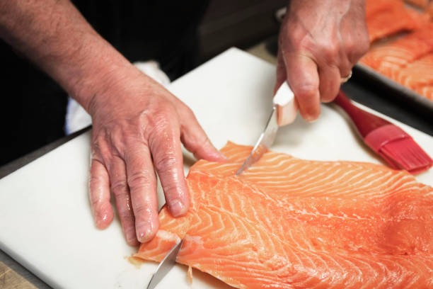 Hand cutting steaks of salmon stock photo