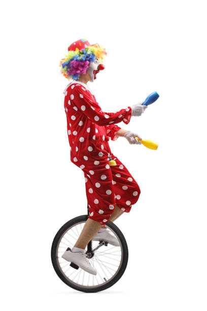 istock Juggler clown riding a unicycle and juggling 1159680006