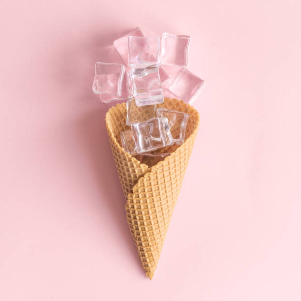 istock Ice cubes in ice cream cone abstract isolated on rose. 1159680572