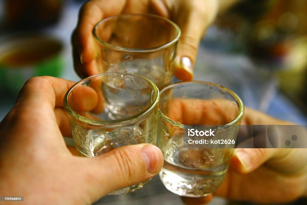 Three hands holding shot glasses of Russian vodka russian vodka Alcohol - Drink Stock Photo