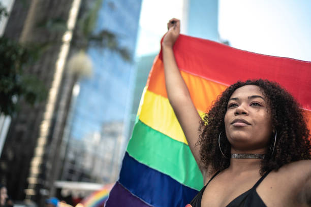 istock Woman waving rainbow flag during pride parade 1159690473