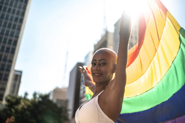 istock Confident lesbian woman holding rainbow flag 1159695860