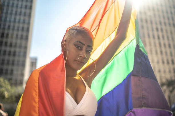 istock Confident lesbian woman holding rainbow flag 1159695875