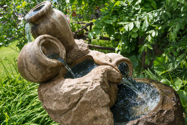 Mini fountain or waterfall of jugs in outdoors, nature, greenery. look beautiful and suitable for background