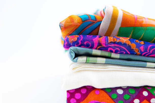 Stacked fabrics with vivid colors and patterns. Isolated on white background with negative space.
