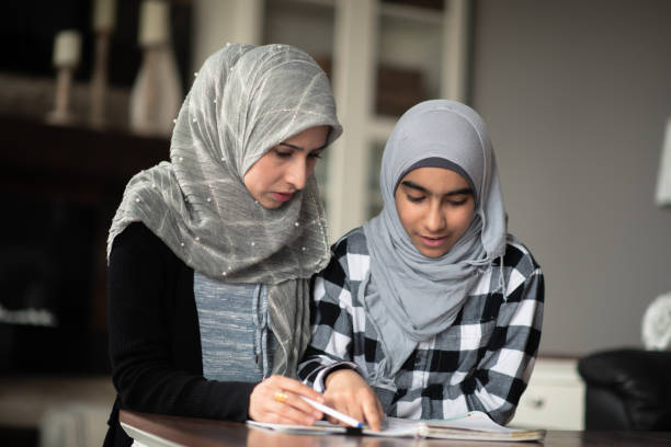 istock Ethnic mother helping her daughter with homework 1159700114