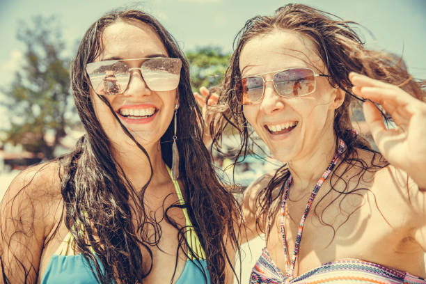 istock Friends playing in waves on beach 1159700238