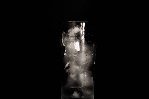 istock Melting ice in a glass isolated on a black background 1159701542