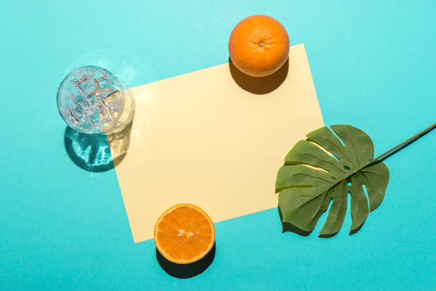 istock Tropical palm leaf with sliced orange on bright blue background. Minimal summer composition. Flat lay. 1159703051