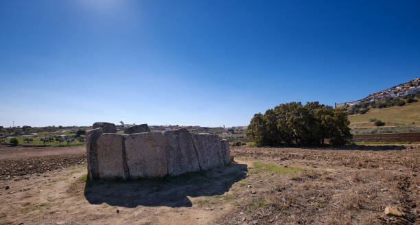 dolmen di "cerca del marco", antica costruzione megalitica con la città di magacela sullo sfondo. extremadura. spagna - dolmen stone grave ancient foto e immagini stock