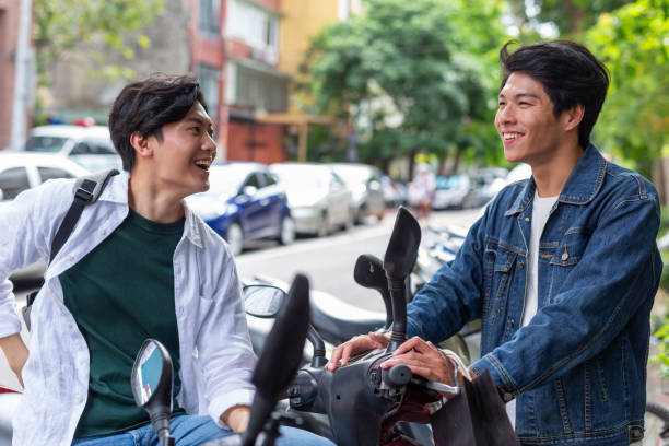 istock Young Asian Men Talking With Motor Scooters 1159707634