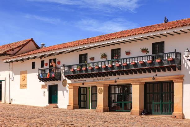 villa de leyva, colombia - looking at establishments on calle 12 that borders the south western side of the cobblestoned plaza mayor in the historic 16th century andean, colonial town in the boyacá department, in the morning sunlight - shingle bank imagens e fotografias de stock