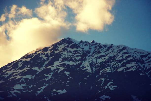 istock Sunlight highlighting the snowy mountain peaks in Alaska 1159710146