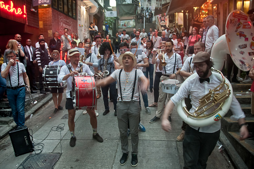 HONG KONG, HONG KONG SAR - NOVEMBER 17, 2018: Local French musician s gathers to play music for mini concert in Lan Kwai Fong Alley in the evening. There are many people in the scene.