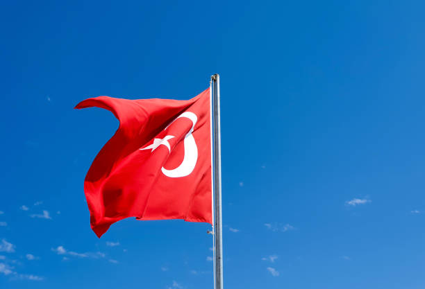 istock The Turkish flag flies on the blue sky background 1159716792
