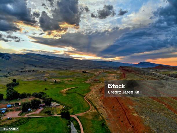 Aerial View Of Red Cliffs Ranch Green Fields And Mountains At Sunset Stock Photo - Download Image Now