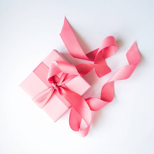 istock Pink gift box with a pink ribbon on a white background . 1159721749