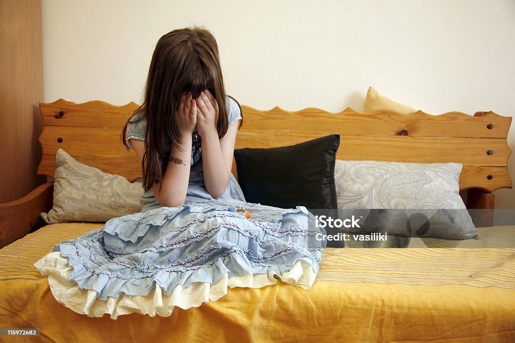 Mujer triste en un sofá - Foto de stock de Niñas libre de derechos