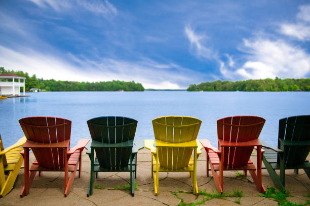 istock Multicoloured Adirondack chairs overlooking a lake 1159727709
