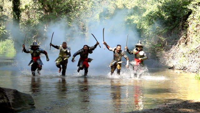 Slow Motion Shot Of Ancient Warriors Running And Shouting To Fight With Enemy At The River