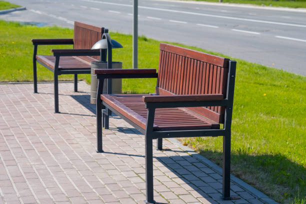 istock Wooden bench for rest and garbage bin in a city park. 1159733858