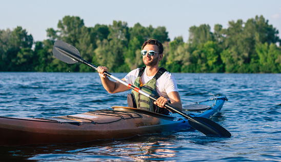 Man paddling a kayak. Concept for adventure, travel, action, lifestyle