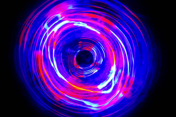 istock LED violet and blue light spinning in the dark. 1159736249