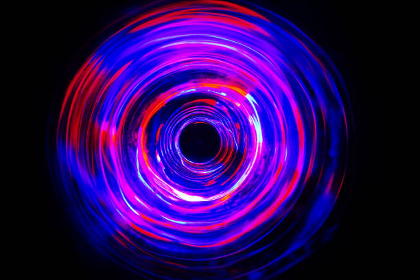 istock LED violet and blue light spinning in the dark. 1159737034