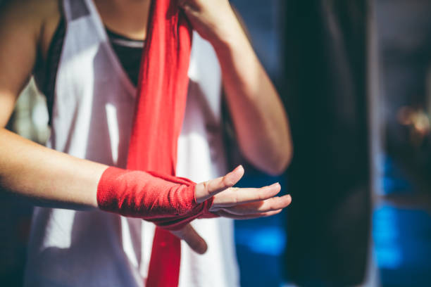 Tying up sports glove Young caucasian woman tying up sports glove and preparing for a training. women boxing sport exercising stock pictures, royalty-free photos & images