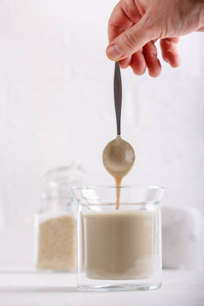 istock Tahini sauce in glass jar on white background. Natural paste made from sesame seeds. 1159739488