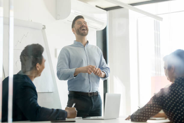 istock Smiling male presenter laugh at briefing meeting in office 1159741227
