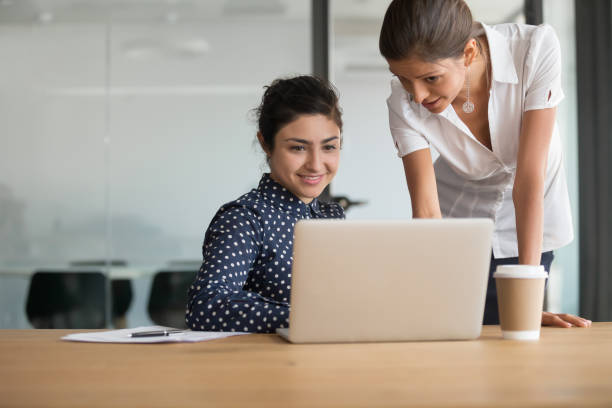 istock Female colleagues discuss project brainstorming using laptop 1159741270