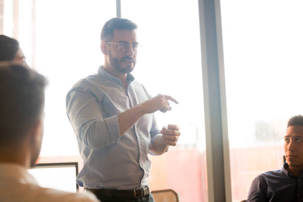 istock Male team leader talk discussing ideas with diverse colleagues 1159741297