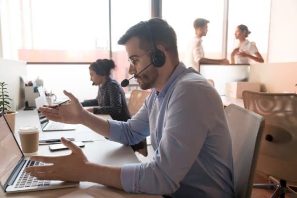 Male telemarketer in headset consult client online