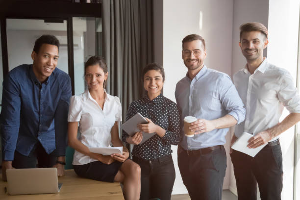 istock Smiling multiethnic team stand making group picture together 1159741307