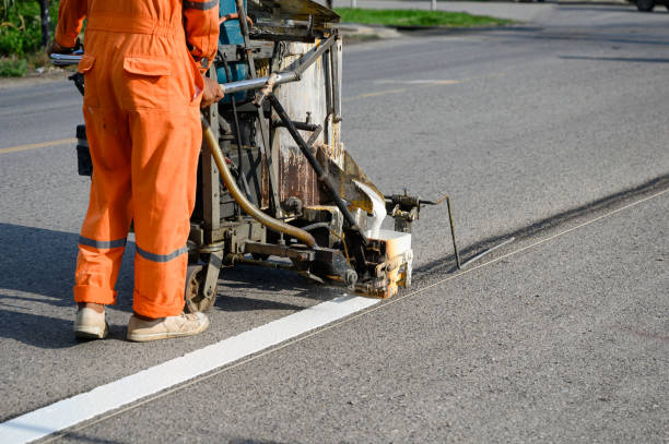 istock Worker wearing uniform is making the white line on road with painting machine 1159741366