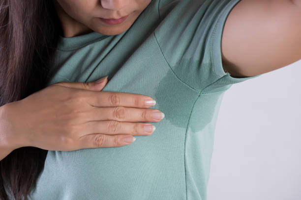 femme asiatique de plan rapproché avec la transpiration d'hyperhidrosis. jeune femme d'asie avec la tache de sueur sur ses vêtements sur le fond gris. concept de soins de santé. - sueur photos et images de collection