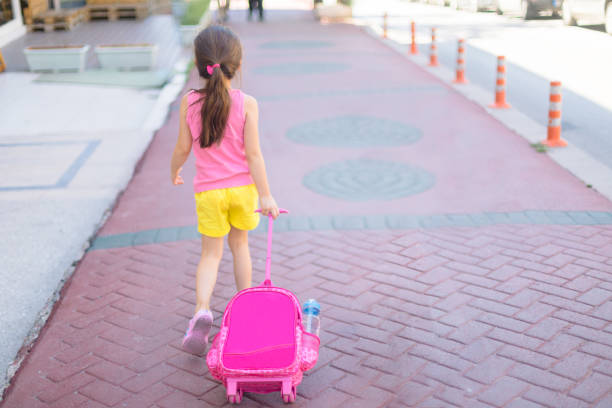 Portrait of happy, little girl returning from school