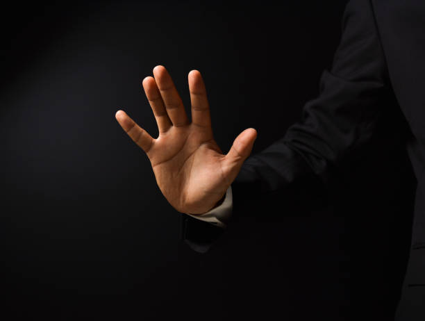 istock Businessman's hand on black background 1159743462