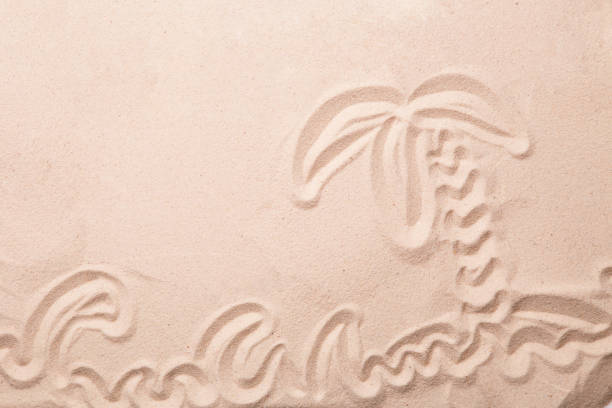 istock Palm and waves are painted in the sand. 1159744802