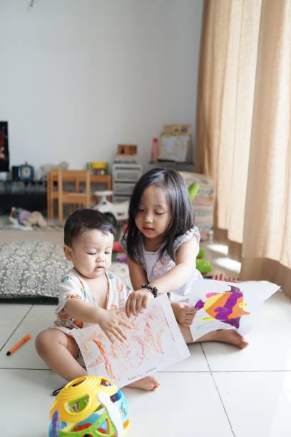 istock Two siblings playing together at home 1159745322