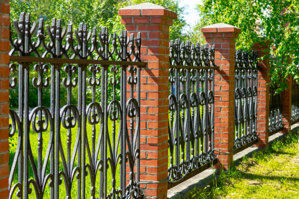 istock Black metal fence with brick pillars 1159751903