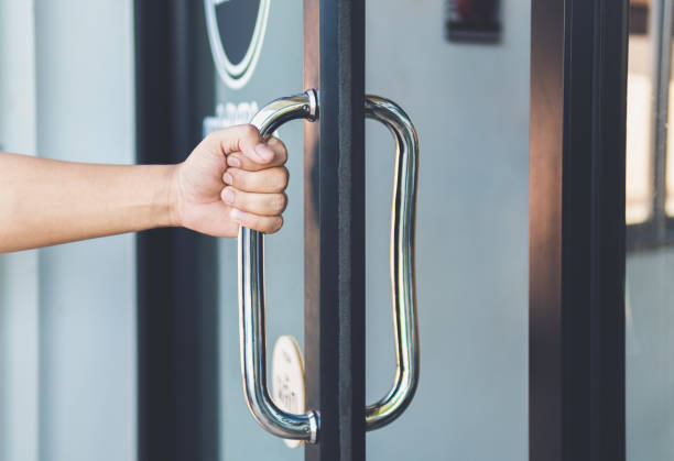 Man hand open the door with glass reflection background