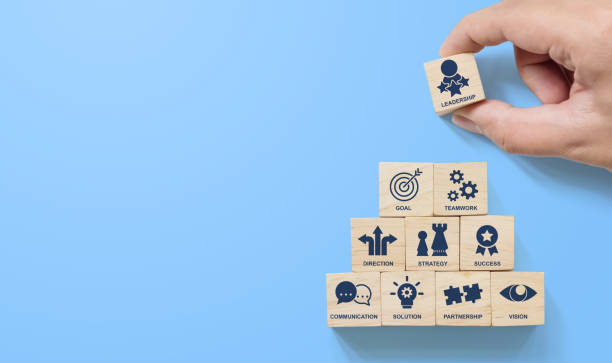 рука организации деревянных блоков укладки пирамиды с иконой лидер бизнеса на синем фоне. ключевые факторы успеха концепции элементов лид� - success business growth key стоковые фото и изображения