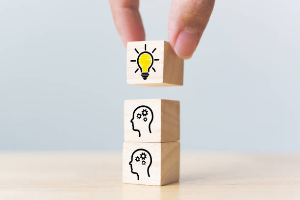 istock Concept creative idea and innovation. Hand picked wooden cube block with head human symbol and light bulb icon 1159754340