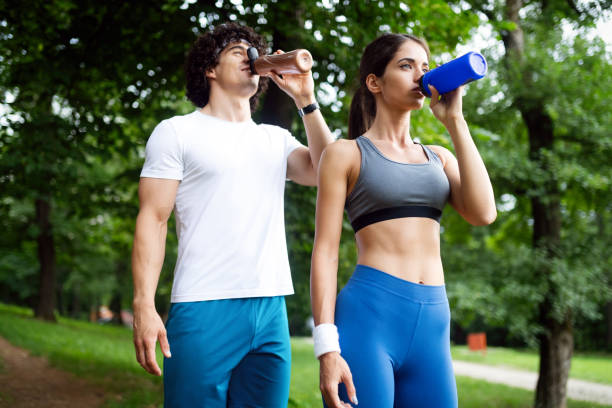 istock Athletic couple friend drinking water after running 1159754765