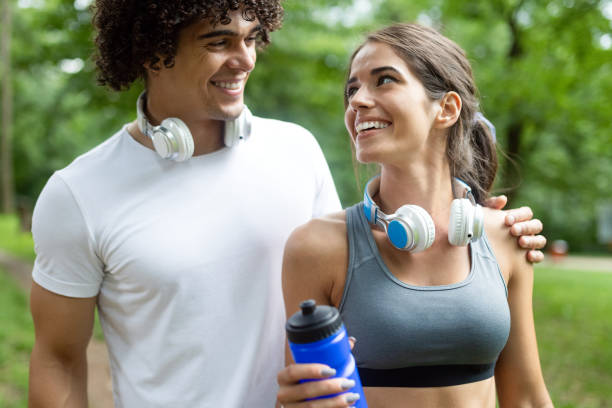 istock Athletic couple friend drinking water after running 1159754826