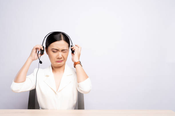 woman operator in headset feel annoyed over white background - center occupation headset on the phone imagens e fotografias de stock