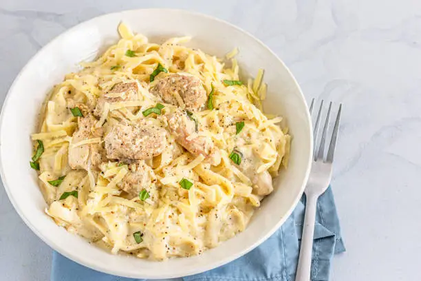 One Pot Chicken Alfredo Pasta in a Bowl Directly from Above and Close-Up Photo. Creamy Chicken Pasta with Basil Leaves, Italian Food Photography."n